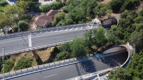 Aerial close top-down view of high highway bridge and mountain tunnel