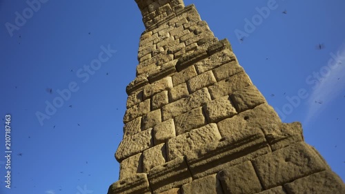 Low angle architectural view of the Roman Aqueduct of Segovia against a clear blue sky