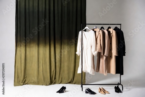Modern Fashion Display with Clothes Rack and Elegant Footwear on Neutral Gray Background