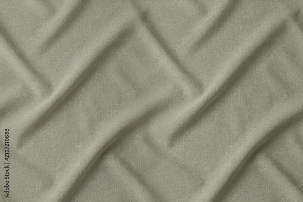 Obraz premium Close up view of sage green fabric with a diagonal quilted pattern creating soft shadows and highlights on the textured textile surface