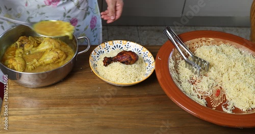 Serving traditional Moroccan Seffa with chicken by pouring onion sauce over steamed vermicelli