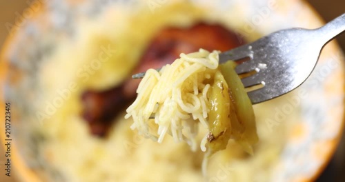 Macro close-up of a fork holding a delicious bite of Moroccan Seffa vermicelli with onion sauce