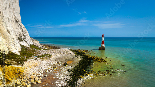 Konstfotografi Aerial drone view of Beachy Head Lighthouse standing beneath the towering white chalk cliffs along the English Channel near Eastbourne, England, with crystal-clear coastal waters and rocky shoreline