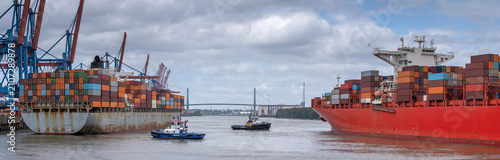 Container Ship, Tugboat and Gantry Cranes at Altenwerder Terminal in Hamburg Harbor
