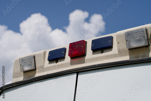 Cuadro en lienzo Rear special signals on the roof of an ambulance vehicle under a cloudy blue sky