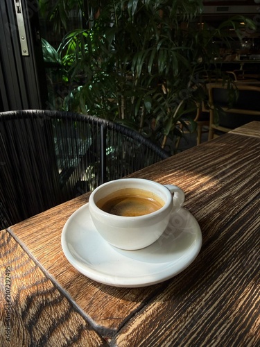 Fresh Espresso Coffee in White Cup on Wooden Table in Cozy Cafe