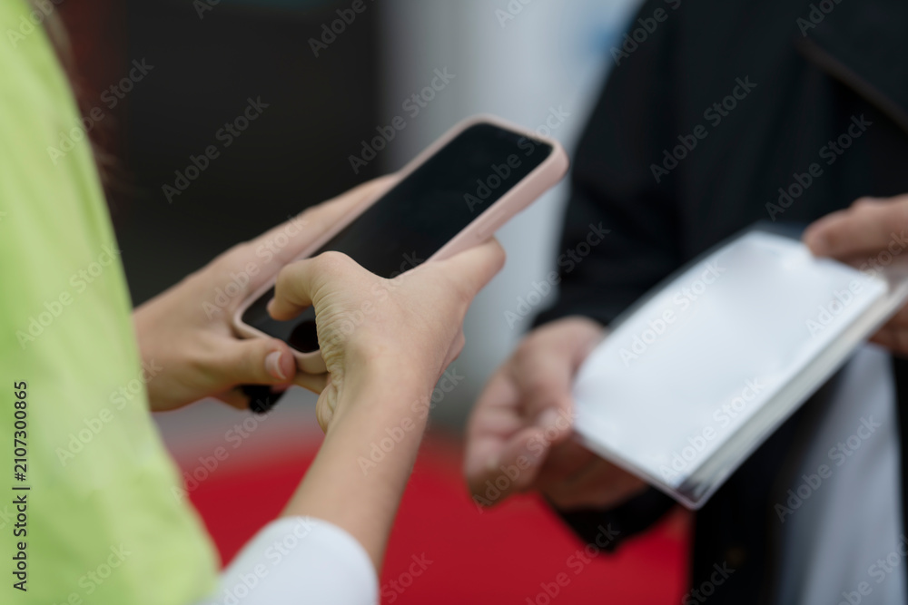 Fototapeta premium People Scanning QR Codes with Smartphones at Business Conference Registration