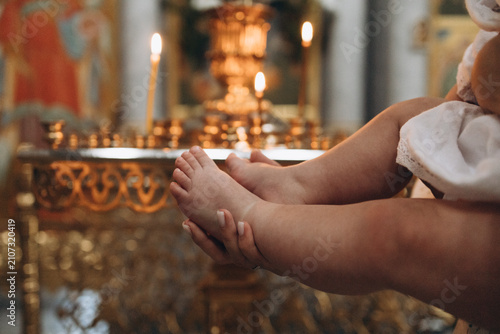 Foto Close-up of a mother gently holding her baby's tiny feet during a Christian baptism ceremony in church
