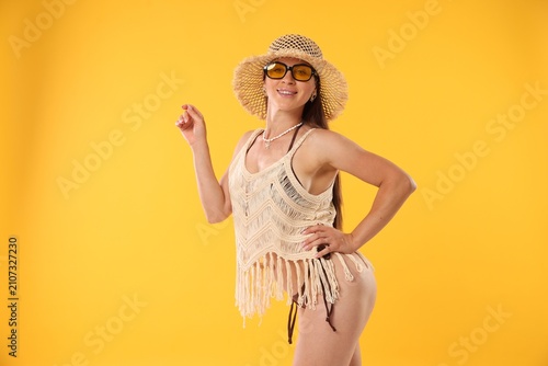 Bilde på lerret Beautiful woman in stylish beachwear on orange background