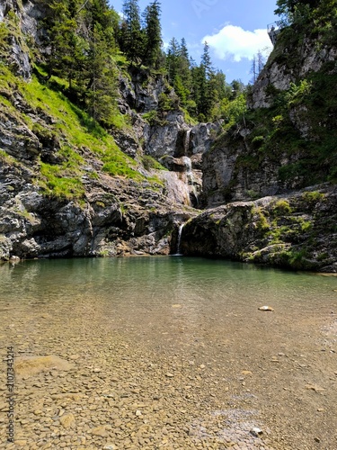 Crystal Clear Alpine Waterfall in a Mountain Canyon

Crystal-clear alpine water flowing into a natural mountain pool surrounded by dramatic limestone cliffs and lush f