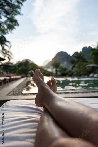 Legs relaxing by pool watching beautiful mountain sunset