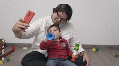 Mother and son taking a fun selfie together while playing with toys