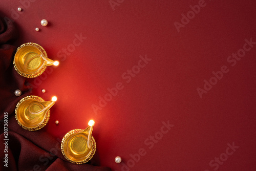 Fotografie Happy Diwali celebration with traditional oil lamps and golden diya on red verti