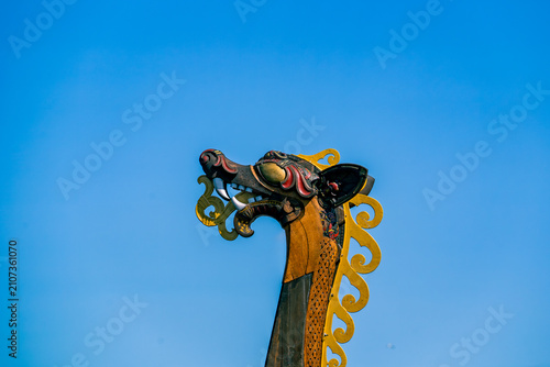 Quadro em tela Carved dragon head figurehead of a Viking ship against blue sky