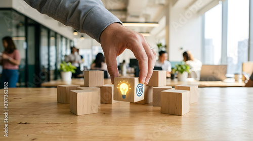 Businessman hand choosing wooden cube with idea light bulb and target icon.