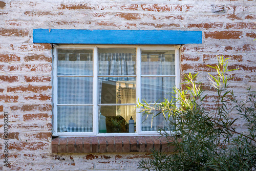фотографія Kitchen window on an old brick ranch or farm house with bright blue trip