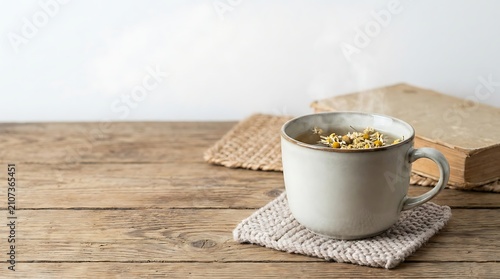 A white mug filled with cereal sits on a woven coaster atop a rustic wooden table with a book in the background.