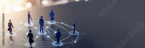 Conceptual image of a professional social and business network with stylized blue figures connected by a digital hub and spokes pattern on a dark reflective surface