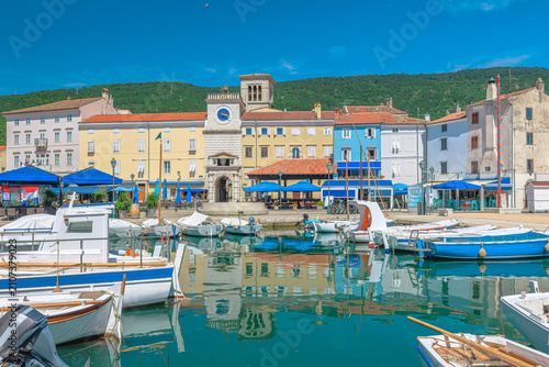 Historic harbor of Cres town on Cres Island, Croatia. Colorful Venetian buildings, traditional fishing boats and Adriatic waterfront in the Kvarner Bay on a sunny summer day in Cres Island of Croatia.