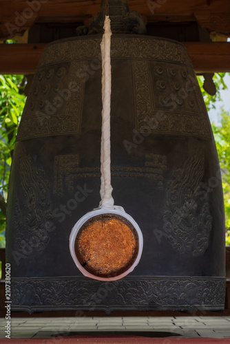 Cuadro en lienzo Close-up of a large Korean bronze temple bell and wooden striker for buddhist rituals