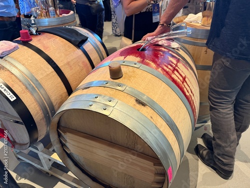 Foto Person Sampling Red Wine from Oak Barrel with Wine Thief