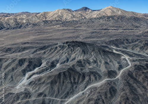 Aerial satellite view of Pickaxe Mountain in Iran, a spectacular rocky mountain landscape with steep ridges, arid terrain, geological formations, remote wilderness, and topographic texture