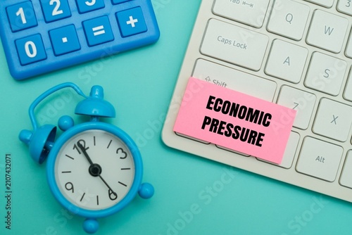 Quadro su tela Pink sticky note with ECONOMIC PRESSURE text on a keyboard next to alarm clock and calculator