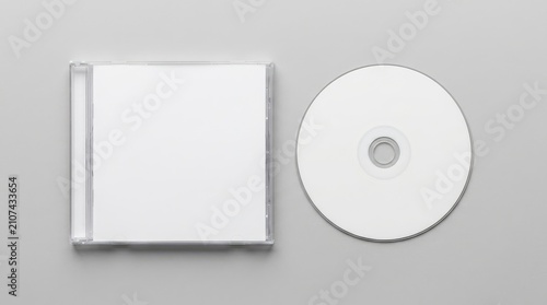 Blank white compact disc and clear plastic jewel case displayed on a smooth gray surface