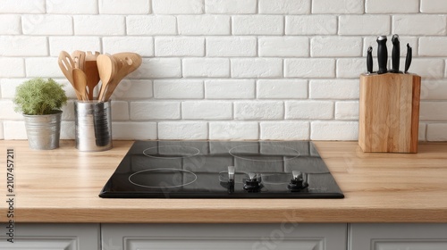 Modern kitchen with cooktop utensils and brick tile background for cooking