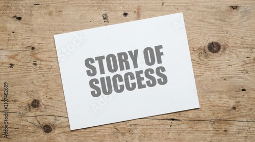 Close-up of white card with Story of Success text on wooden background with natural light