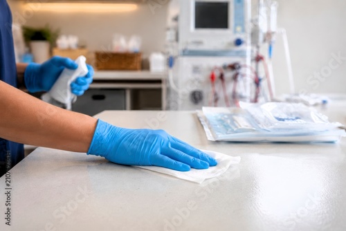 Medical cleaning home dialysis treatment room with gloved hand wiping sterile surface for infection control and safe patient care