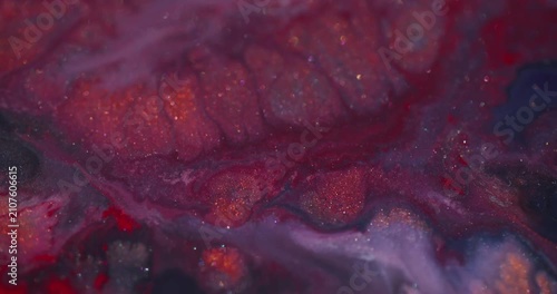 Glitter spill defocused. Ink blend. Red fluid explosion on shimmering color texture with purple gray particles on abstract background.