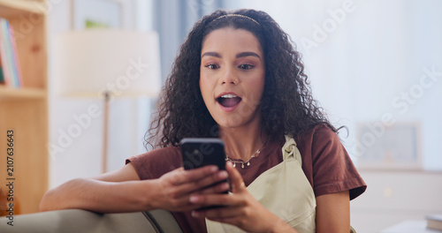 Foto Phone, shock and woman on sofa in home with texting, social media or networking on mobile app