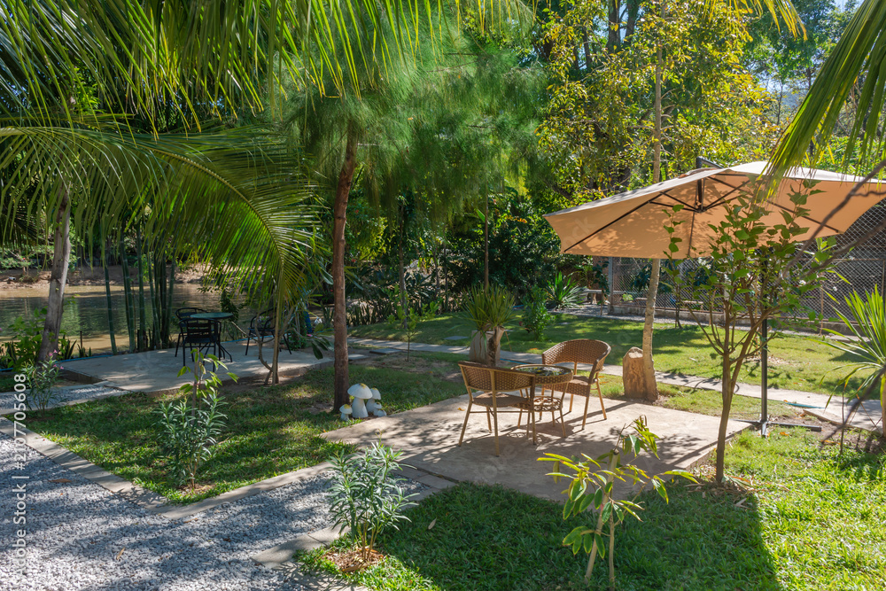 Obraz premium Tropical garden patio with outdoor seating for drink at cafe.