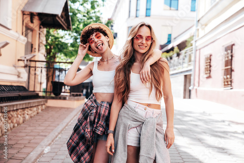 Canvas Print Two young beautiful smiling hipster female in trendy summer white t-shirt and shorts clothes