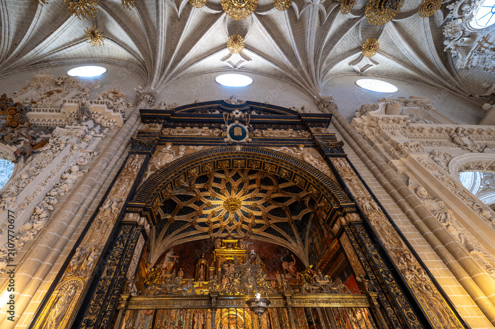 Fototapeta premium Low angle vertical view of the Parish Chapel (Capilla de la Parroquia or San Miguel) entrance, featuring a star-patterned mudéjar vault, ornate iron grille, dark marble archway, and gothic ribbed vaul