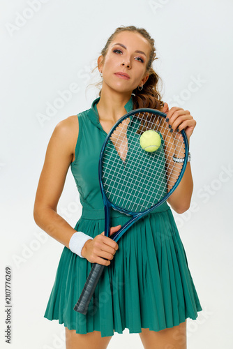 Bild auf Leinwand A young athlete stands confidently holding a tennis racket with a ball, showcasi