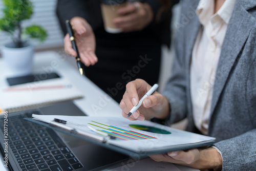  The business team reviews financial and accounting reports using calculators and laptops during meetings in the office.
