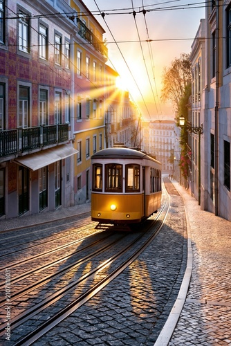 Yellow tram climbing a steeped lisbon street, golden sun shining over traditional old town buildings
