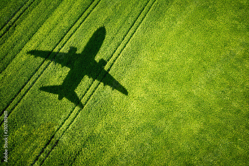 airplane shadow on green grass field aerial view concept with copy space. aerial view photo of an airplane shadow cast over a vibrant green agricultural field.