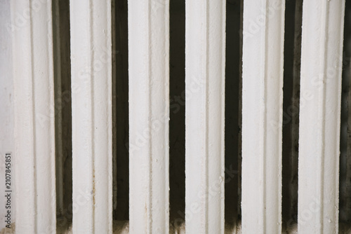 Vertical white columns create a pattern against a dark background. The scene emphasizes architectural lines and contrasts in color.