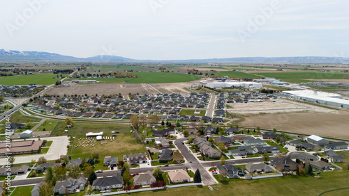 Obraz na płótnie Aerial view of a residential subdivision next to industrial buildings and open fields