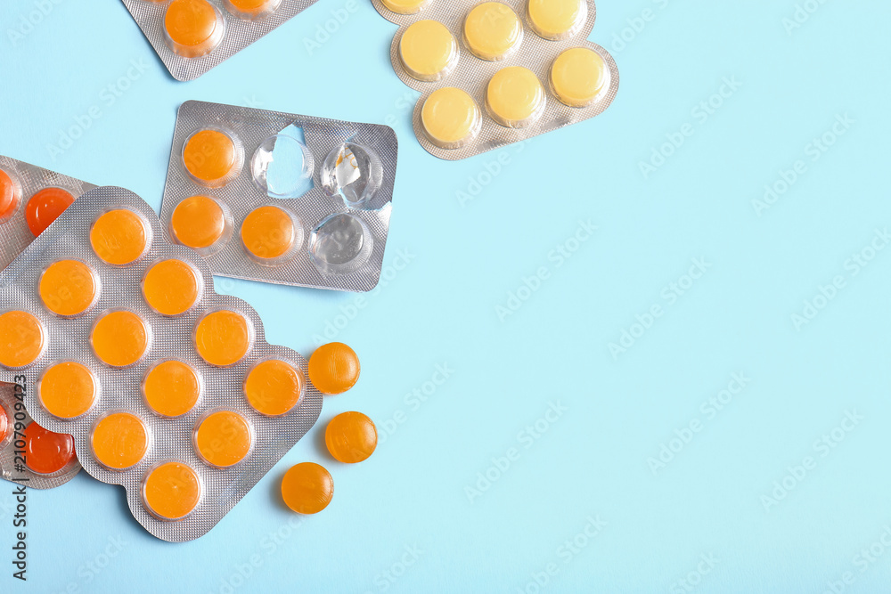 Obraz premium Blisters with cough drops on blue background