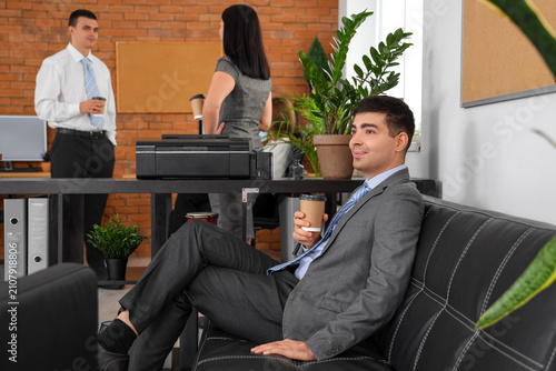 Businessman having coffee break in office