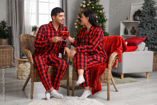 Young couple with glasses of mulled wine at home on Christmas eve