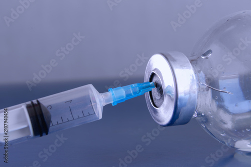Tableau sur toile Close-Up Of Syringe Needle Filling Vaccine Vial For Medical Injection And Vaccin