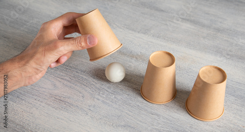 Magician shows game of thimbles with a cups.