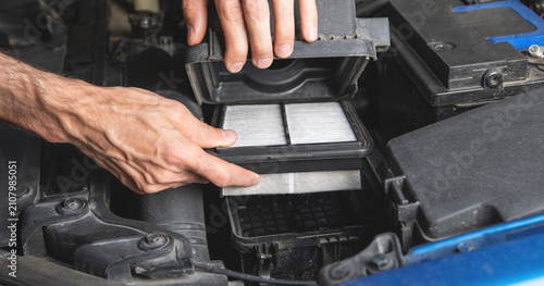 Man change a car cabin air filter.