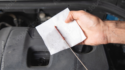 Man checking car engine oil.