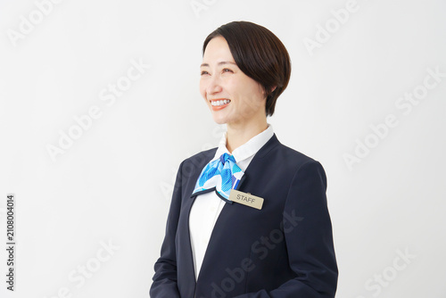 Obraz na plátne 白背景で横を向き微笑む40代女性スタッフ